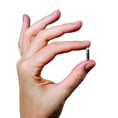 En hand som håller en Eversense E3-glukossensor.