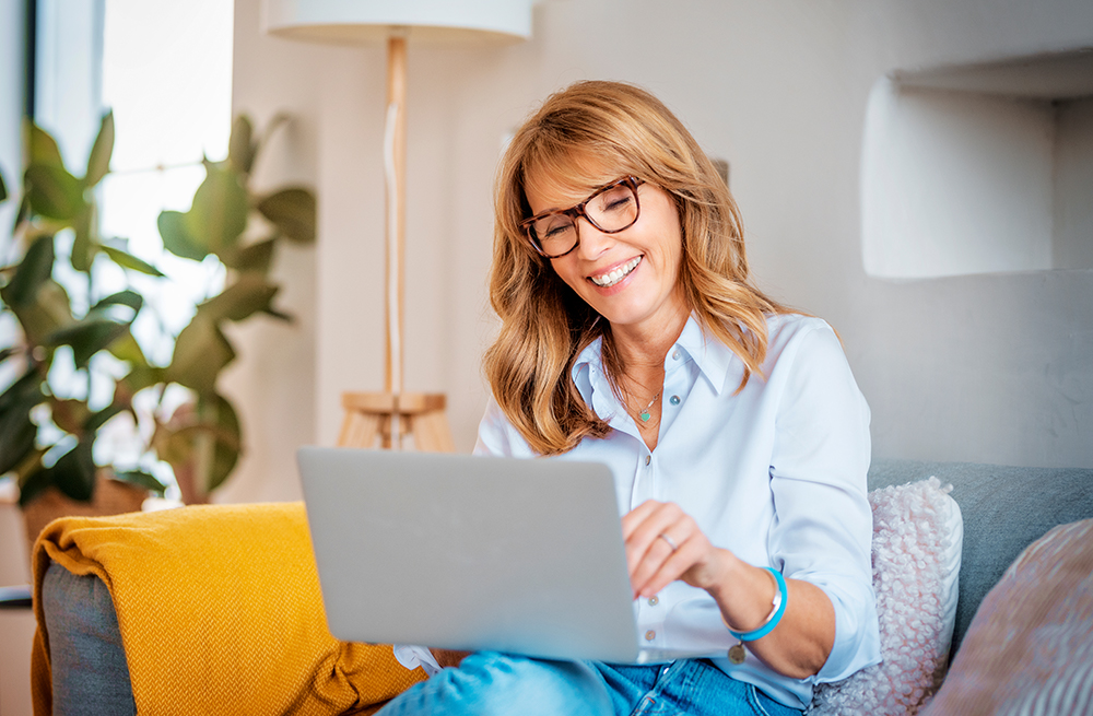 Woman using a laptop to find out does insurance cover continuous glucose monitors?